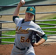 Un joueur de baseball lançant une balle avec son bras droit.