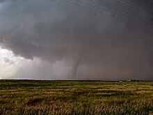 A tornado, seen from a distance over flat country