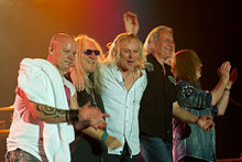 Foto von Uriah Heep in der Besetzung des Jahres 2011, aufgenommen in Würzburg bei einem Konzert in der Posthalle am 8. Mai 2011. Die Musiker stehen und nehmen die Ovationen des Publikums entgegen.