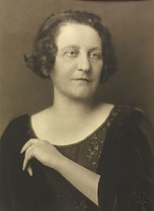 Portrait of a woman with short hair in a dark-scoop necked dress