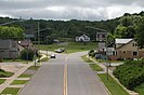 A road with two lanes in each direction, with houses and small businesses along the sides