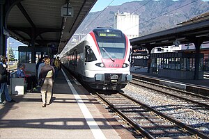 Red-and-white train on double-track at island platform