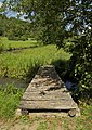 Una passerella pedonale che utilizza travi su un ruscello in Dordogna, Francia