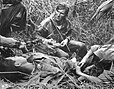 Patrice Le Nepvou de Carfort, médecin du 8e Bataillon de parachutistes coloniaux, apporte les premiers secours à un parachutiste autochtone blessé sur la piste Pavie pendant la bataille de Ðiện Biên Phủ en Indochine.