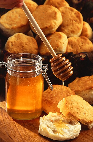 A jar of honey with honey dipper.