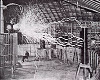 Publicity picture of a participant sitting in his laboratory in Colorado Springs with his "Magnifying Transmitter" generating millions of volts of electricity. The arcs are about 7 meters (22 ft) long. (Tesla's notes identify this as a double exposure.)