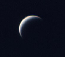 black and white image of Venus, its edges blurred and a small crescent of its surface illuminated