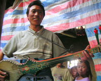 Hombre tibetano tocando un dramyin