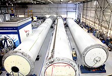 Длинные цилиндрические секции ракеты лежат на складе