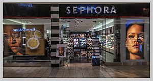 یک ویترین فروشگاه Sephora با پوسترهای بزرگ که دو عکس از نمای نزدیک ریانا و لوازم آرایشی را نشان می‌دهد.