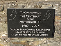 Plaquette in Kirk Michael die herinnert aan het 100-jarige bestaan van de Isle of Man TT. Kirk Michael lag langs de St John's Short Course, maar ook langs de Highroads Course, de Four Inch Course en de Snaefell Mountain Course