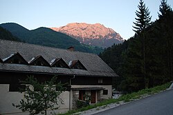 A solčavai közösségi ház, háttérben a Raduha-hegy