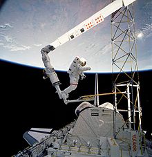 Jerry Ross rides the Remote Manipulator System while testing space station construction techniques in the payload bay of Atlantis during STS-61-B. Structures in Space - GPN-2000-001080.jpg
