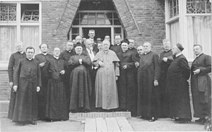Een aantal katholieke geestelijken uit de provincie Groningen met architect Jos Cuypers (met baard) voor de ingang van de kerk tijdens een feestelijke kerkwijding in 1927.