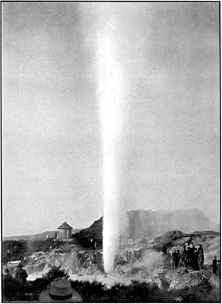 Tall column of white steam with tourists and shelter around base