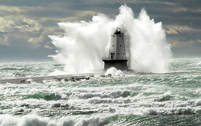 Waves tower over the 57-foot-tall Ludington Lighthouse in Michigan. Show another
