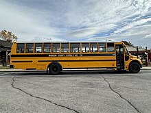 A photograph of a yellow and black school bus parked.