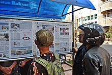 Newspaper readers in Bandung Newspaper reader (26852176070).jpg