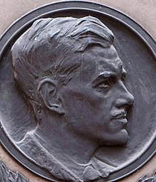 Bas-relief profile of young man with short, swept-back 1920s hairstyle and moustache