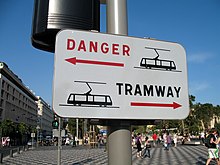 Image représentant un panneau d’avertissement de passage du tramway avec la mention « DANGER TRAMWAY » accroché sur un poteau.