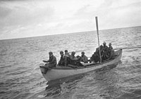 The final landing of the Macquarie Island party. Mac can be seen being held near the centre of the boat.