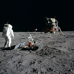 Astronaut Buzz Aldrin with scientific equipment, US flag, television camera and Apollo Lunar Module at Tranquility Base. Photo by Neil Armstrong
