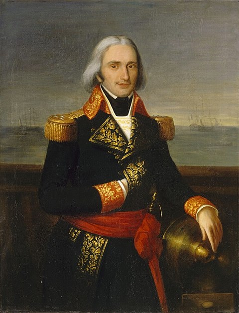 Un homme avec de long
                  cheveux blancs dans un uniforme naval richement décoré
                  se tient sur le pont d'un navire.