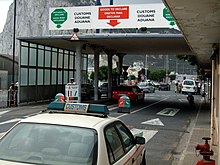 Cars crossing into Gibraltar from Spain clearing customs formalities. Gibraltar is outside the customs union, VAT area, and Schengen Zone. Gibraltar Customs side of the Spain-Gibraltar frontier, Winston Churchill Avenue, Gibraltar.jpg