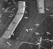 Photo aérienne en noir et blanc de champs jonchés de carcasses d'aéronefs.