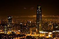 Night view of the financial sector of Santiago. At the center, the Gran Torre Santiago, the tallest building in Latin America. At the upper back, the lights of the three ski resorts of the central Andes.