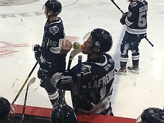 Description de l'image Alexis Lafreniere rehydrates during a stoppage in play.jpg.