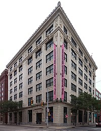 An ornate corner building built of white teracotta.