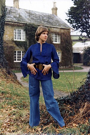 Джинси кльош у поєднанні з блузою стилізованою під середні віки, зачіска "паж", Англія, середина 1970-их