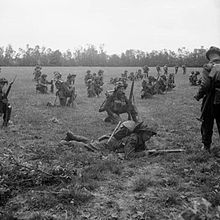 Photo présentant des fantassins britanniques arme au poing, dans un champ, attendant le signal pour lancer l'attaque