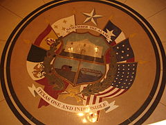 Mosaicu col escudu de Texas, amosando los seis banderes de Texas.