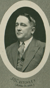 an oval-shaped black and white head and shoulders photograph of a man in a 1930s style suit