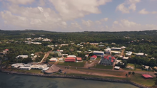 Photographie du survol en drone de Mata Utu, chef-lieu de Wallis-et-Futuna bordant la mer.