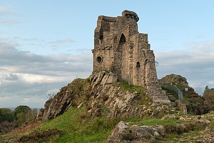 Castelo Mow Cop, um folly do século XVIII construído para se assemelhar a um castelo em ruínas, situado na fronteira entre os condados de Cheshire e Staffordshire, Reino Unido. Em 1754, Randle Wilbraham, da vizinha Rode Hall, construiu uma elaborada casa de veraneio que parecia uma fortaleza medieval e uma torre redonda. O castelo foi entregue ao National Trust em 1937. Embora originalmente os visitantes entrassem no local, a área ao redor foi cercada devido a várias tentativas de suicídio. O castelo é designado como edifício classificado com o Grau II na Lista do Patrimônio Nacional da Inglaterra. (definição 5 417 × 3 611)