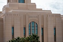 A closeup landscape of Red Cliffs temple with art glass windows and a palladian window. Above the window it carries the inscription- "HOLINESS TO THE LORD THE HOUSE OF THE LORD."