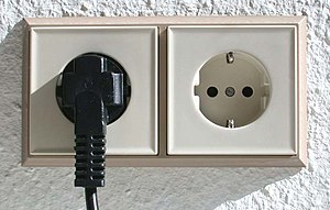 Double Schuko socket with one plug inserted. T...
