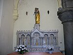 Le tabernacle est surmonté d'une statue de la Vierge à l'Enfant