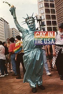 A person holding a rainbow flag during the 1993 March on Washington for Lesbian, Gay, and Bi Equal Rights and Liberation 98.LGBT.MOW.25April1993 (496798468).jpg