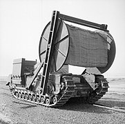 A tank with a large reel of matting carried in front of it