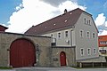 Wohnstallhaus eines Dreiseithofes sowie Hofmauer mit Torbogen und Pforte