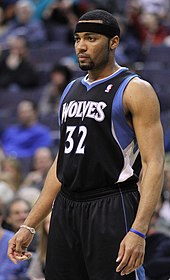 A full body shot of Lazar Hayward in a Timberwolves jersey, wearing a black headband