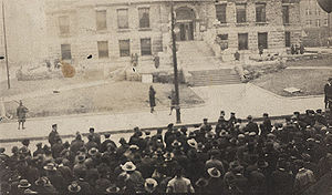 A discolored photo of a mob gathered outside a courthouse