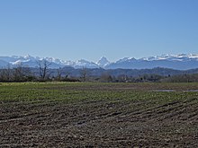 Photographie en couleurs d'un paysage de montagnes enneigées.