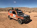 Competitor driving through dry desert terrain