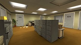 A brightly lit office space with tanish-brown flooring, egg-white walls, and square overhead lights. Several closed doors leading to personal offices and other rooms line the walls, as well as plants and other office-related objects. In the center of the room is a large filing cabinet.