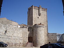 Coria castle. Basically a large square keep, but with several smaller round towers jutting out on all side.